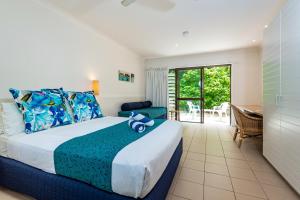 
a hotel room with a bed, table, and window at Heron Island in Heron Island
