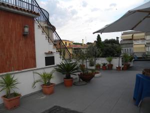 a balcony with potted plants and stairs on a building at Albergo Villa Anna in Anzio