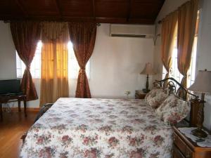 a bedroom with a bed with a floral bedspread at Prime Ocean View Vacation Villa in Plaisance