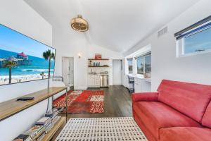 a living room with a red couch and a view of the beach at 6 THE WHITE HOUSE in Huntington Beach