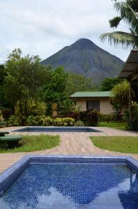 a swimming pool with a mountain in the background at Lumbres Arenal in Fortuna