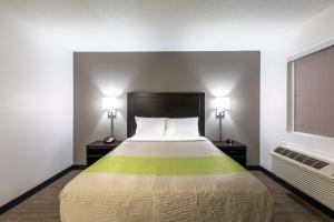 Bett in einem Zimmer mit zwei Lampen und einem Fenster in der Unterkunft Studio 6-Greenville, SC - I-85 Near Downtown in Greenville