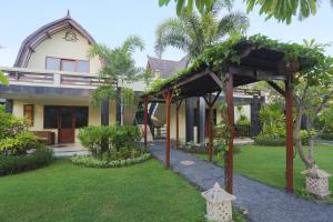 a house with a garden in front of it at Vila Ombak in Gili Trawangan