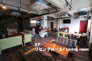 a large room with tables and chairs and a dining room at RED HELMET House & Sports Bar Hiroshima in Hiroshima