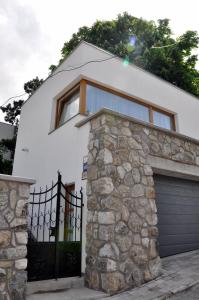 a white house with a gate and a garage at Bratislava Castle Hill Apartment in Bratislava