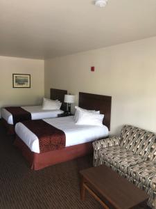 een hotelkamer met 2 bedden en een bank bij Yellowstone Big Rock Inn in Gardiner