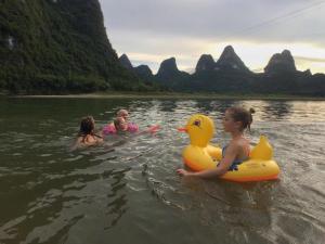 a group of people in the water with a rubber duck at Yangshuo Yunshe Mountain Guesthouse in Yangshuo