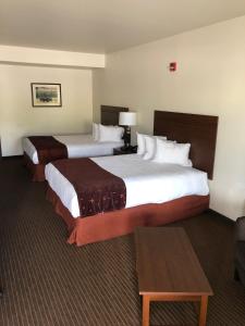 Cette chambre comprend 2 lits et une table. dans l'établissement Yellowstone Big Rock Inn, à Gardiner