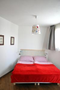 uma cama com um cobertor vermelho num quarto branco em Bratislava Castle Hill Apartment em Bratislava