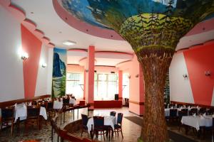 Hotel Bradul في دوراو: مطعم فيه شجرة مرسومة على السقف