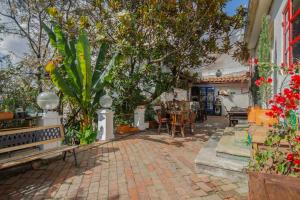 a patio with tables and chairs and trees at Botanico Hostel in Bogotá