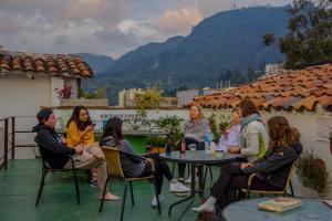 a group of people sitting around a table on a roof at Botanico Hostel in Bogotá