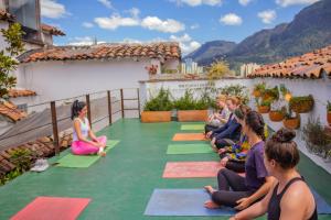 a group of people sitting in a yoga class on a roof at Botanico Hostel in Bogotá
