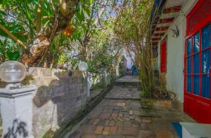 an alleyway with a red door and trees at Botanico Hostel in Bogotá