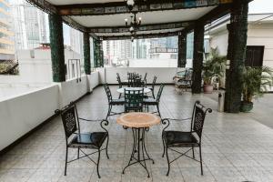 a patio with a table and chairs on a roof at San Agustin Residences in Manila