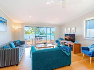 a living room with blue furniture and a view of the ocean at Angourie Blue 4 in Yamba