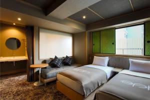 a hotel room with two beds and a couch at eph TAKAYAMA in Takayama