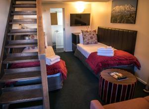 a room with a staircase and a bed and a couch at The Park Hotel Ruapehu in National Park