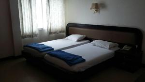 a bedroom with two beds with blue towels on them at Queen Songkhla Hotel in Songkhla