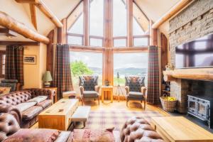 a living room with a fireplace and a large window at Waterloo lodge in Lochinver