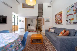a living room with a couch and a table at Colony Suites - Emek Refaim in Jerusalem