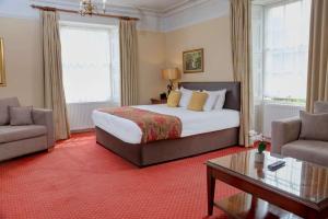 a bedroom with a bed and a couch and a table at Best Western Henbury Lodge Hotel in Bristol +28 photos