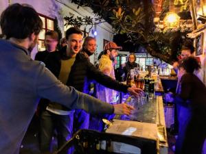 a group of people standing around a bar at Botanico Hostel in Bogotá