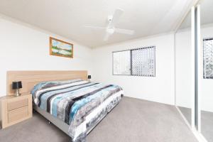 a bedroom with a bed and a ceiling fan at Breakers 3 - linen not included in Forster