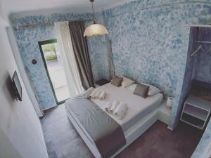 um quarto com uma cama branca e papel de parede azul em Filio Guesthouse em Kypri