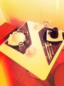 a white table with plates and utensils on it at B&B La Giara in Porto Empedocle