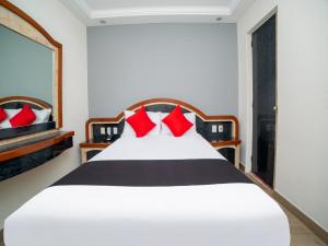 1 dormitorio con cama blanca y almohadas rojas en Hotel Monarca, en Ciudad de México