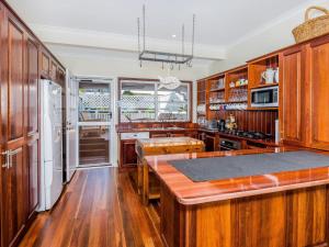 a kitchen with wooden cabinets and a large island at Kenlee in Yamba +13 photos