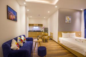 a hotel room with a bed and a blue couch at King House Villa Hotel & Spa in Danang