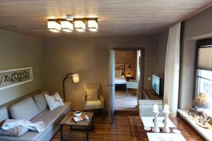 a living room with a couch and a table at Montara Suites Bodenmais I aktivCARD Bayerischer Wald inklusive in Bodenmais