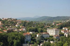 a town in the mountains with houses and trees at Hôtel de Paris in Châtel-Guyon