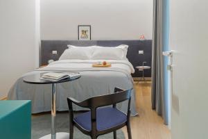 um quarto com uma cama com uma mesa e uma cadeira em The Radical Hotel Roma em Roma