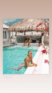 a woman is sitting in a swimming pool at Motel LOVE SONG Canggu in Canggu