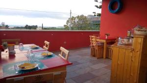 a dining room with a table and a red wall at B&B Albatros in Castelluzzo