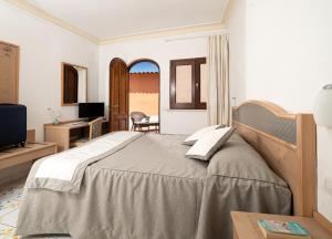 a bedroom with a bed and a desk and a television at Hotel Il Girasole in Anacapri