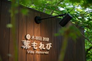 a sign on the side of a wooden fence at Villa Hamorebi in Miyajima