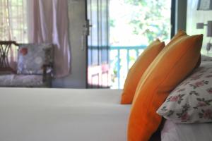 una cama con almohadas naranjas encima en Villa Jacaranda en Varkala