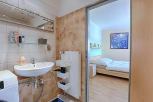 a bathroom with a sink and a bedroom at H-Apartments in Trier