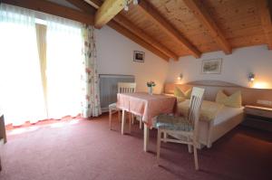 sala de estar con mesa y cama en Landhaus Hofer en Neustift im Stubaital