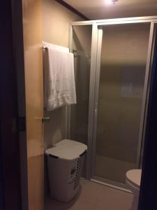 a bathroom with a shower with a toilet and a towel at GOLDEN PEAK CONDO in Cebu City