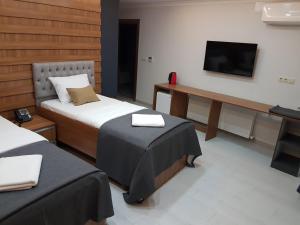 a hotel room with two beds and a television at Vera Suite Hotel Trabzon in Trabzon