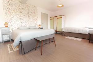 a large bedroom with two beds and a table at Le Nid de Val'Ry in Saint-Valery-sur-Somme