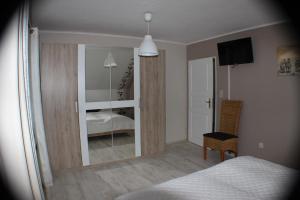 a room with a bedroom with a mirror and a bed at Ferienhaus Abbi mit Schwimmbad und Fitness für 8 Personen, Strand, Norddeich in Hage