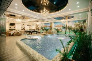 a large swimming pool in a room with a ceiling at Hotel KARAVAN in Urganch