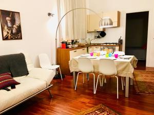 salon ze stołem i białą kanapą w obiekcie A Casa di Enza w Bolonii