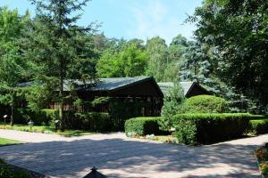 a house with a garden and a driveway at Leśny Ośrodek Szkoleniowy w Puszczykowie in Puszczykowo